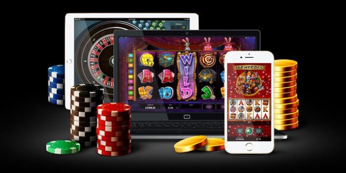 Platta, dator och telefon med casino samt spelmarker och guldmynt